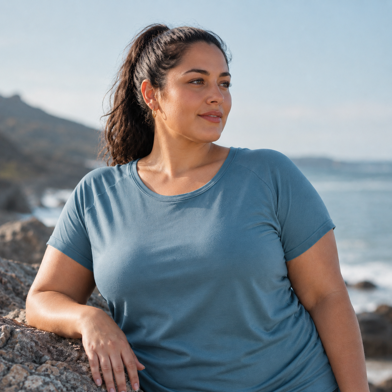 Woman by the ocean looking toward the horizon